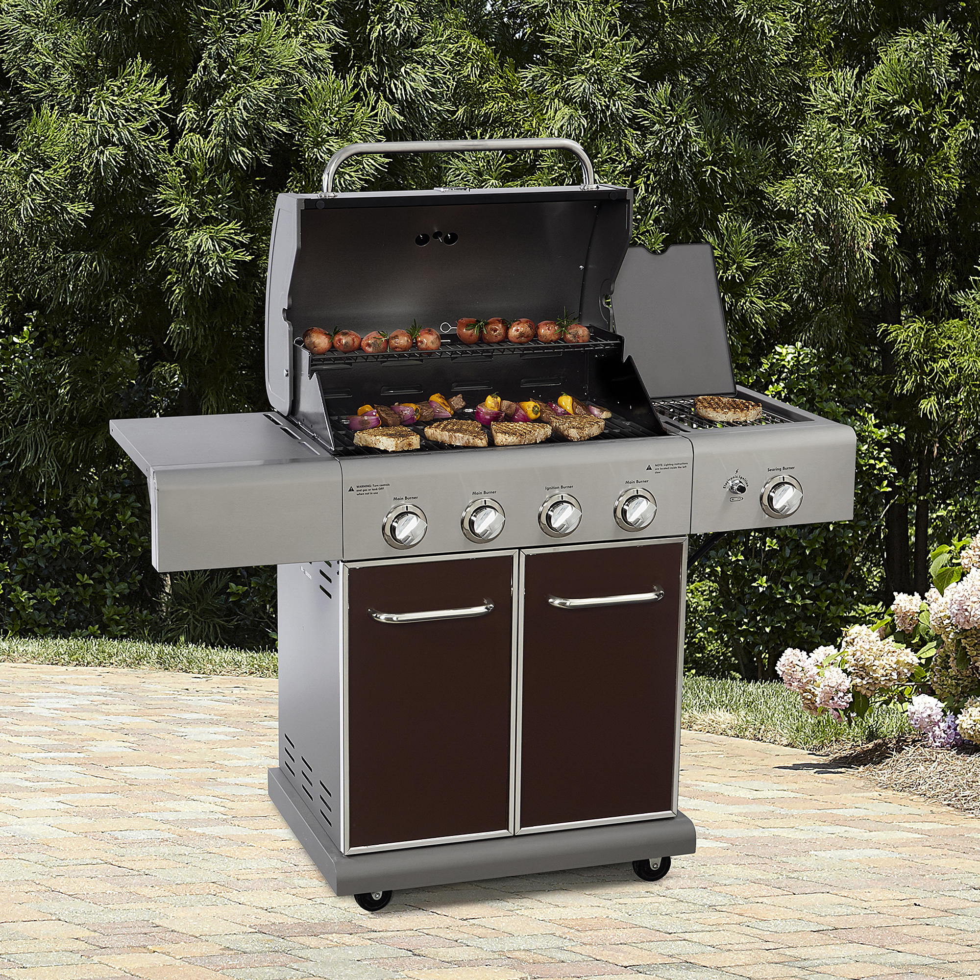 A Kenmore gas grill on a patio.
