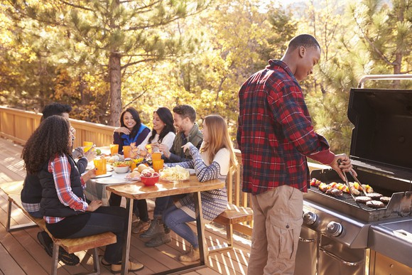 Family sharing a meal on their deck. 