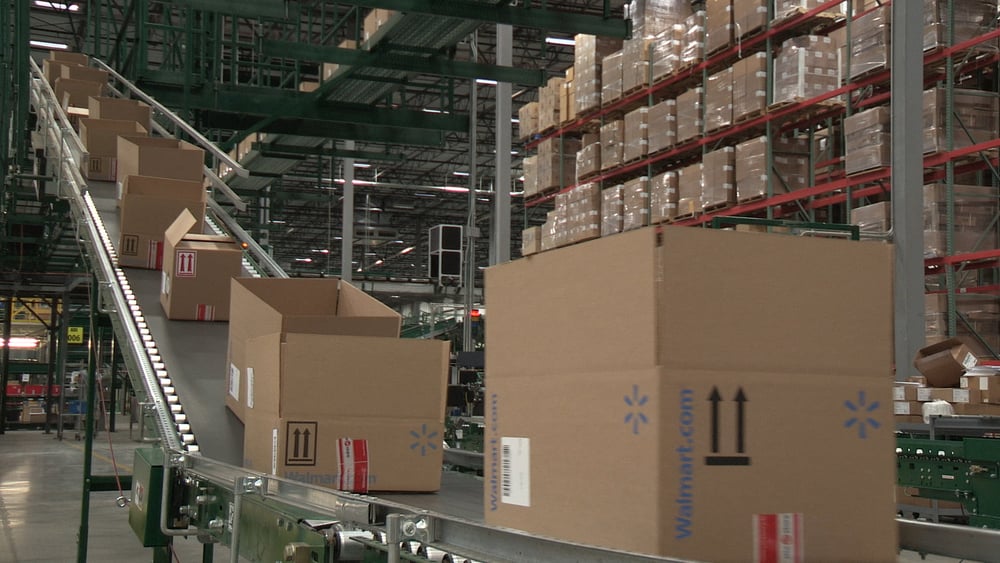 Cardboard Wal-Mart boxes on a sloped conveyer belt in Wal-Mart fulfillment center