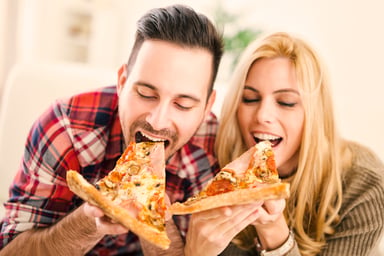 couple eating pizza slices getty