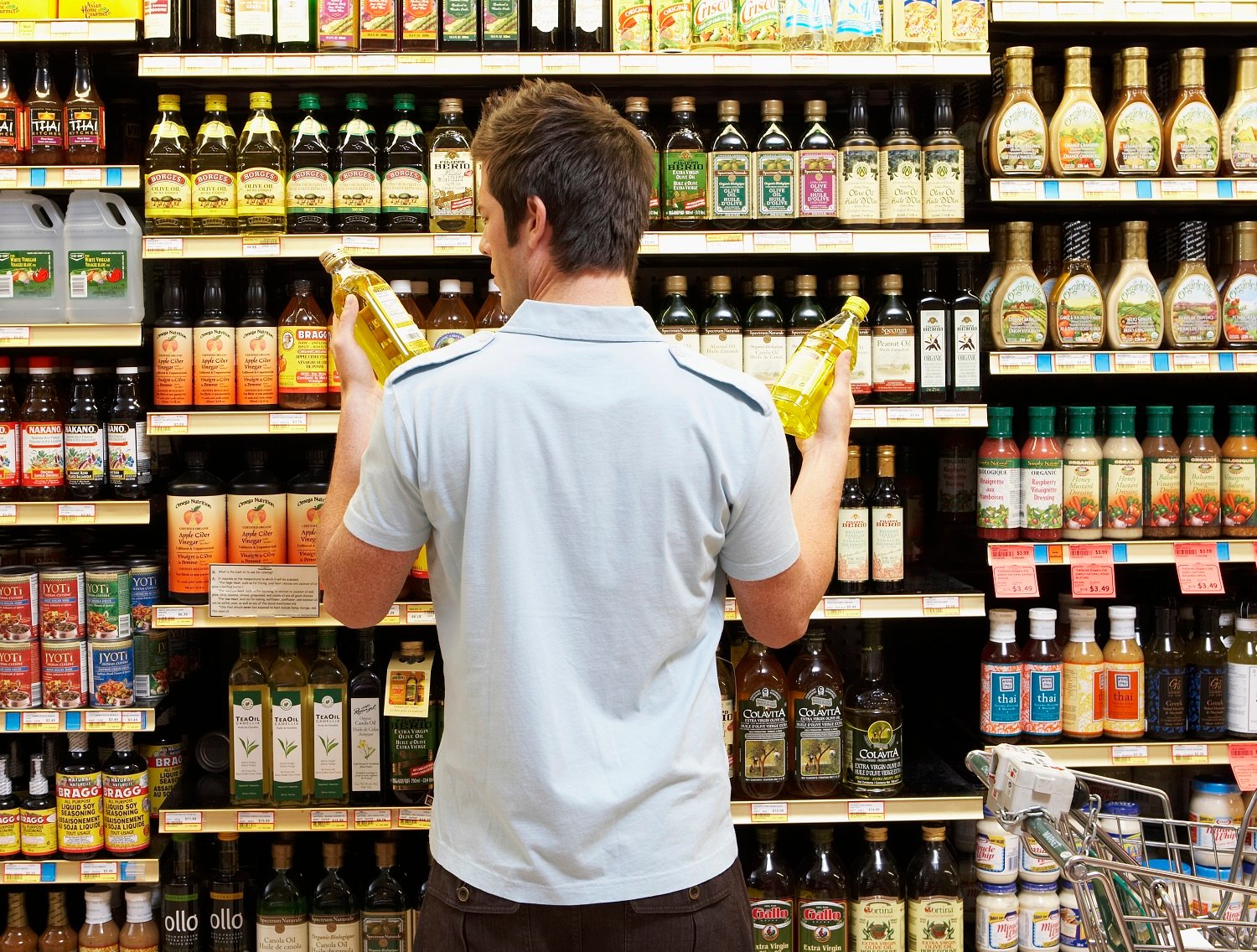 Man comparing products in a grocery store. 