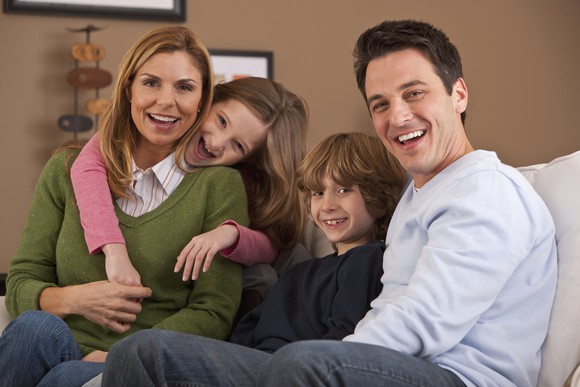 A smiling family portrait with both parents and two kids. 
