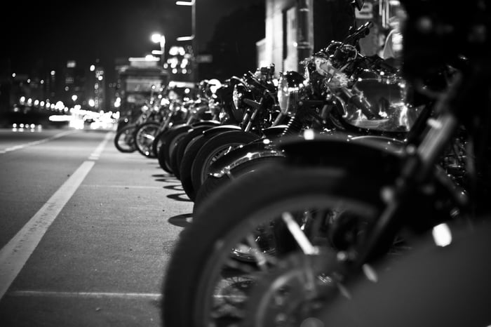 Black & white photo of motorcycles lined up on a street at night