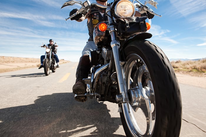 Two motorcycle riders on wide open road