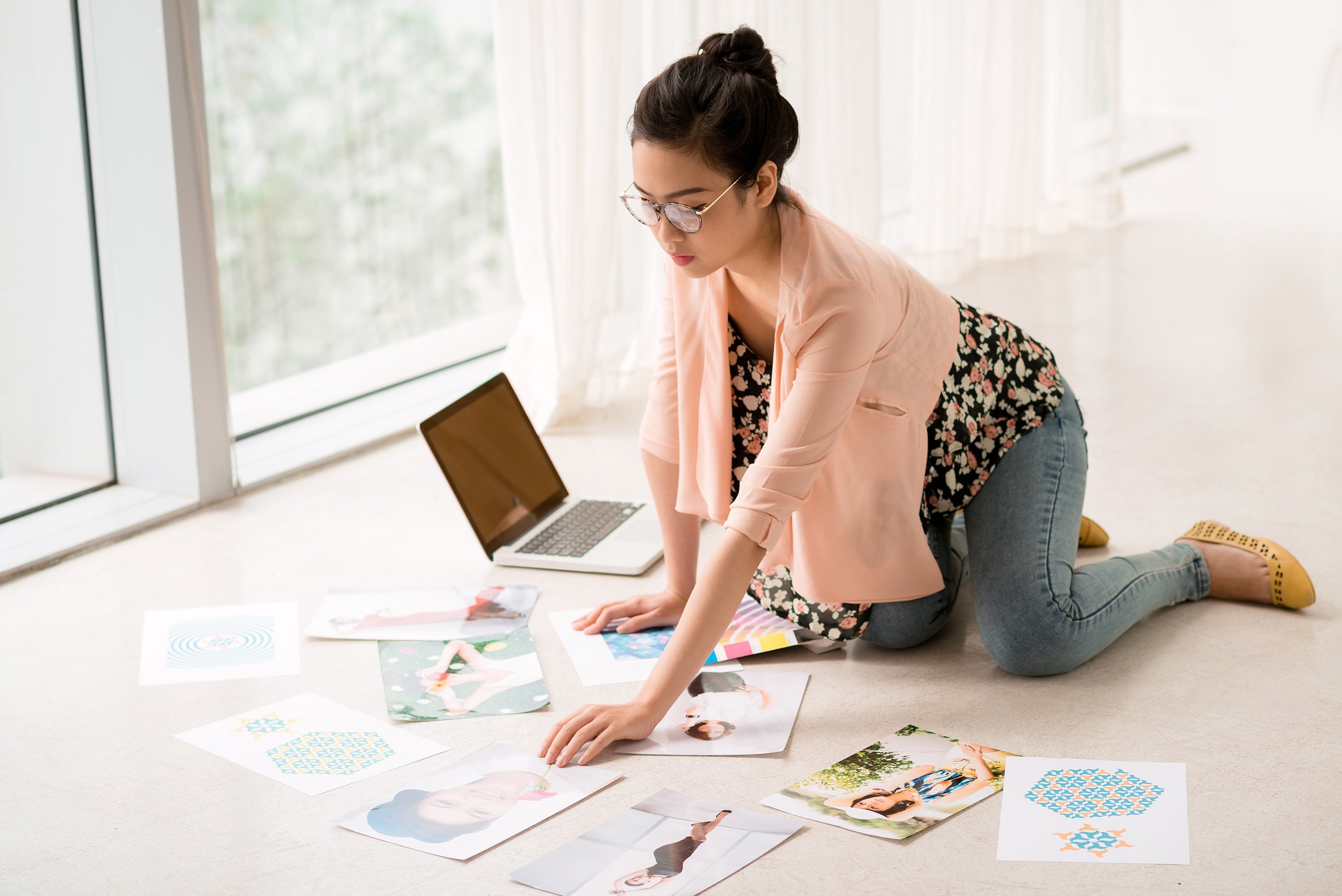 Woman arranging pictures for use in digital portfolio.