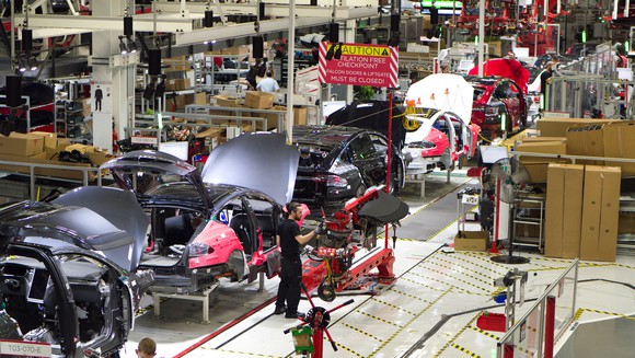 Partially-assembled Model X SUVs move down an assembly line at Tesla's Fremont, California factory.