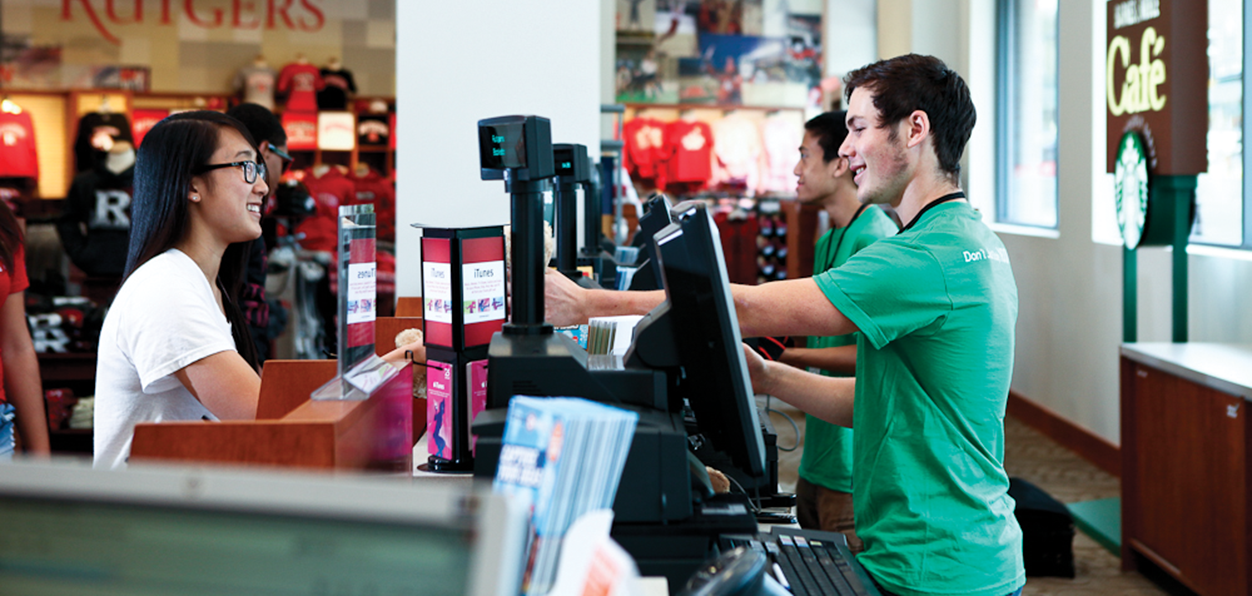Customer at the counter of a Barnes & Noble Education store with clerks.