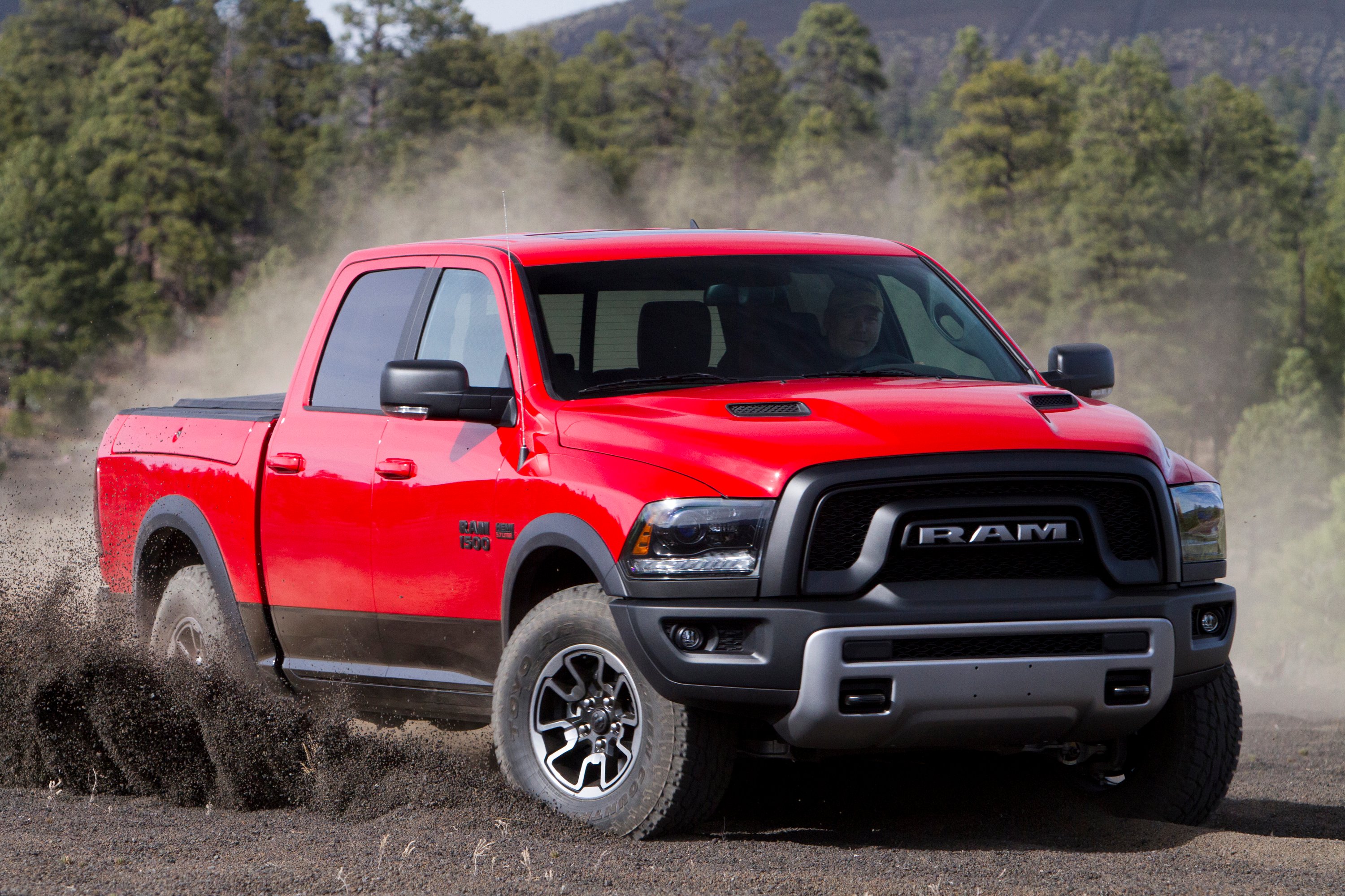 A red Ram 1500 pickup on a dirt road.