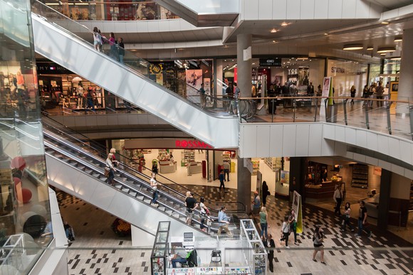 Shoppers on an escalator in a shopping mall.