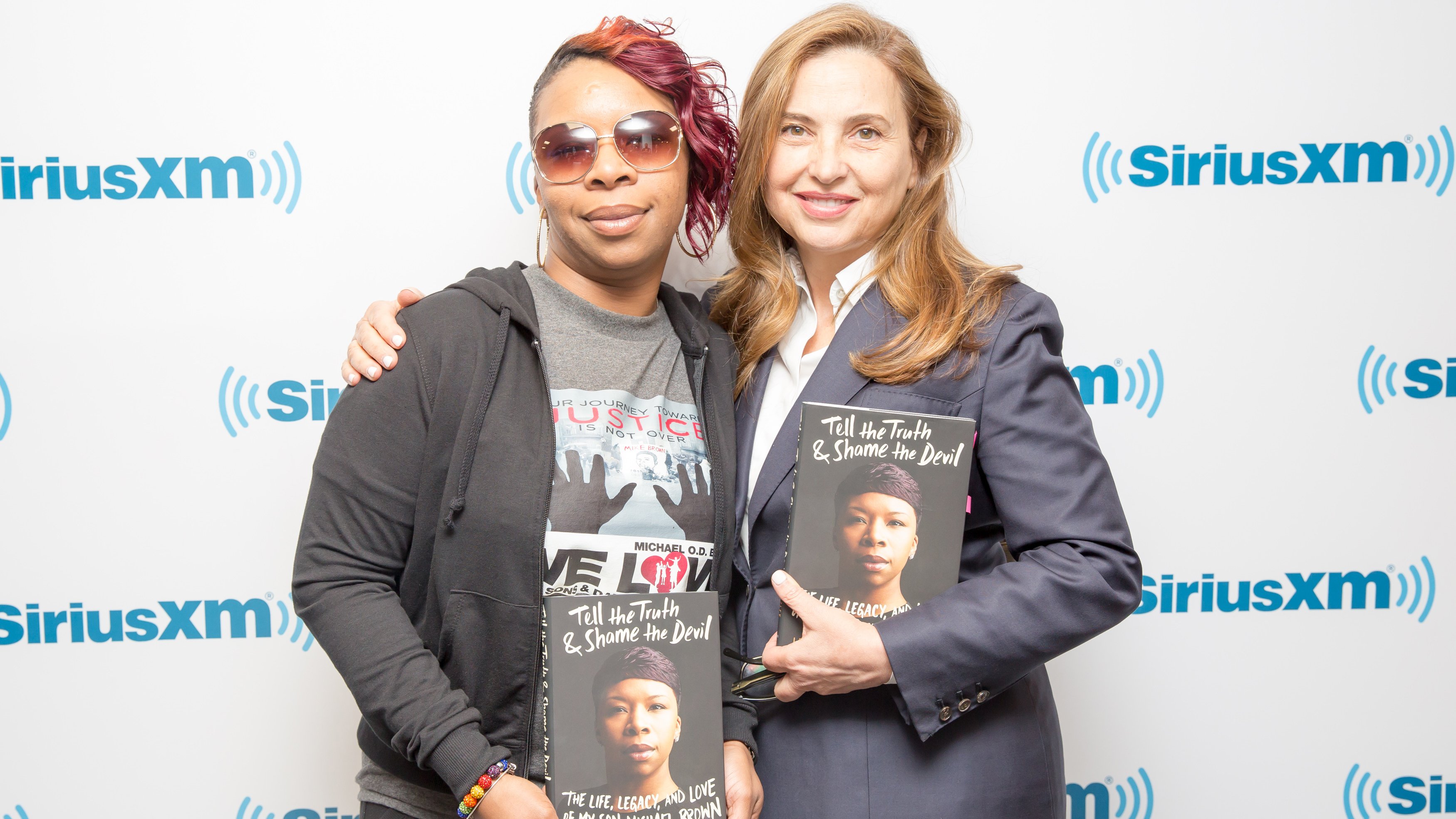 Book tour posing in front of a Sirius XM step and repeat board.