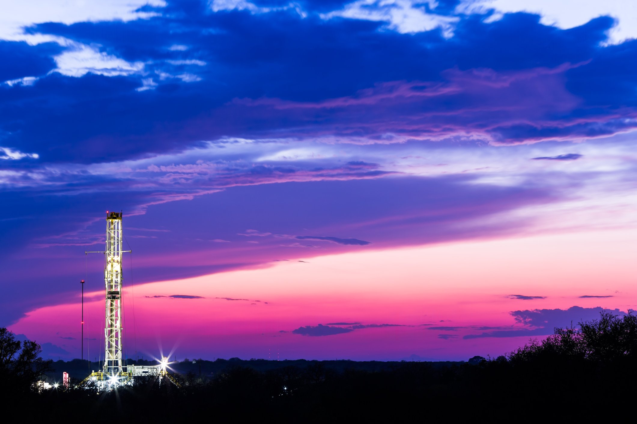 Drilling rig with a pink sky background