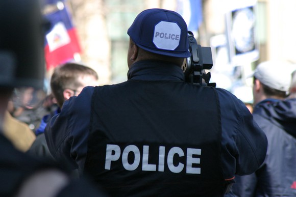 Picture of a police officer recording a protest.