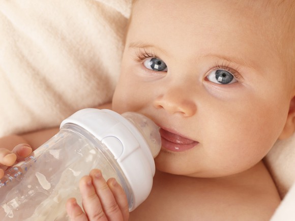 Close-up of an infant drinking from a bottle.