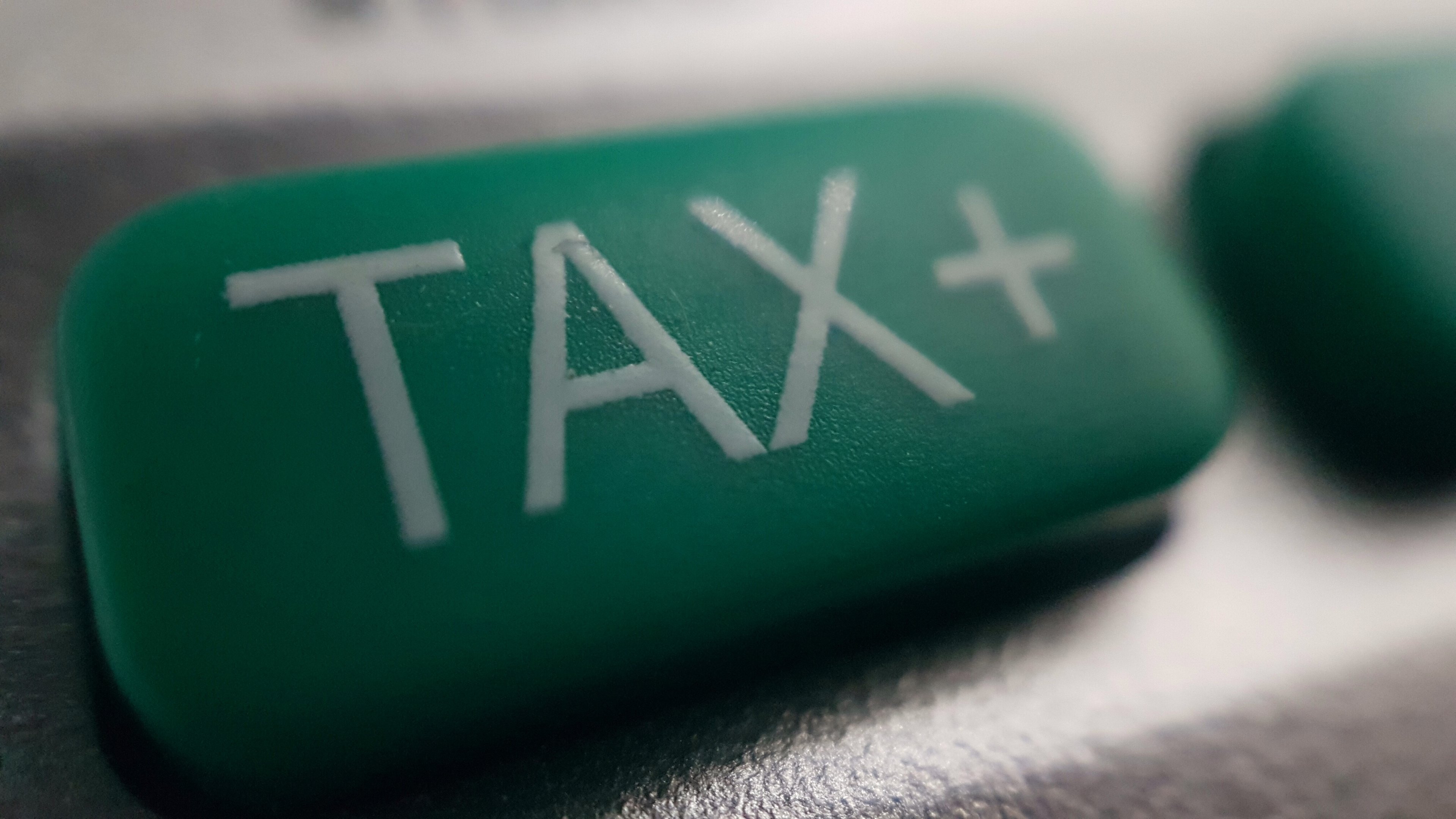 A magnified tax button on a calculator, used to calculate sales and local taxes. 