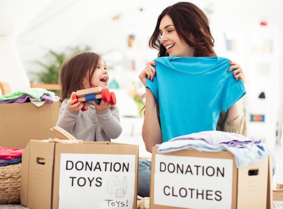 A mother and daughter preparing items to donate to charity.