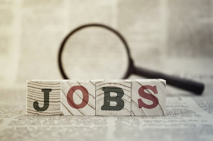 Jobs spelled out in wooden blocks with magnifying glass
