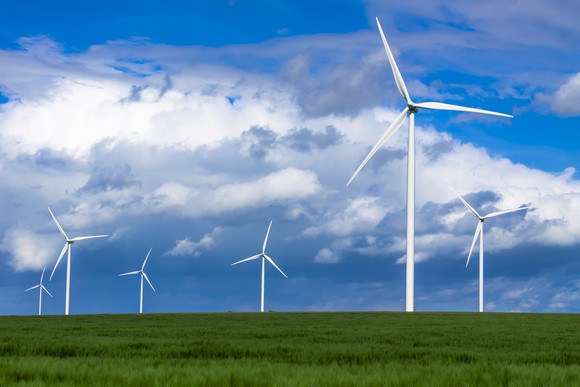 Wind turbines in a green field.