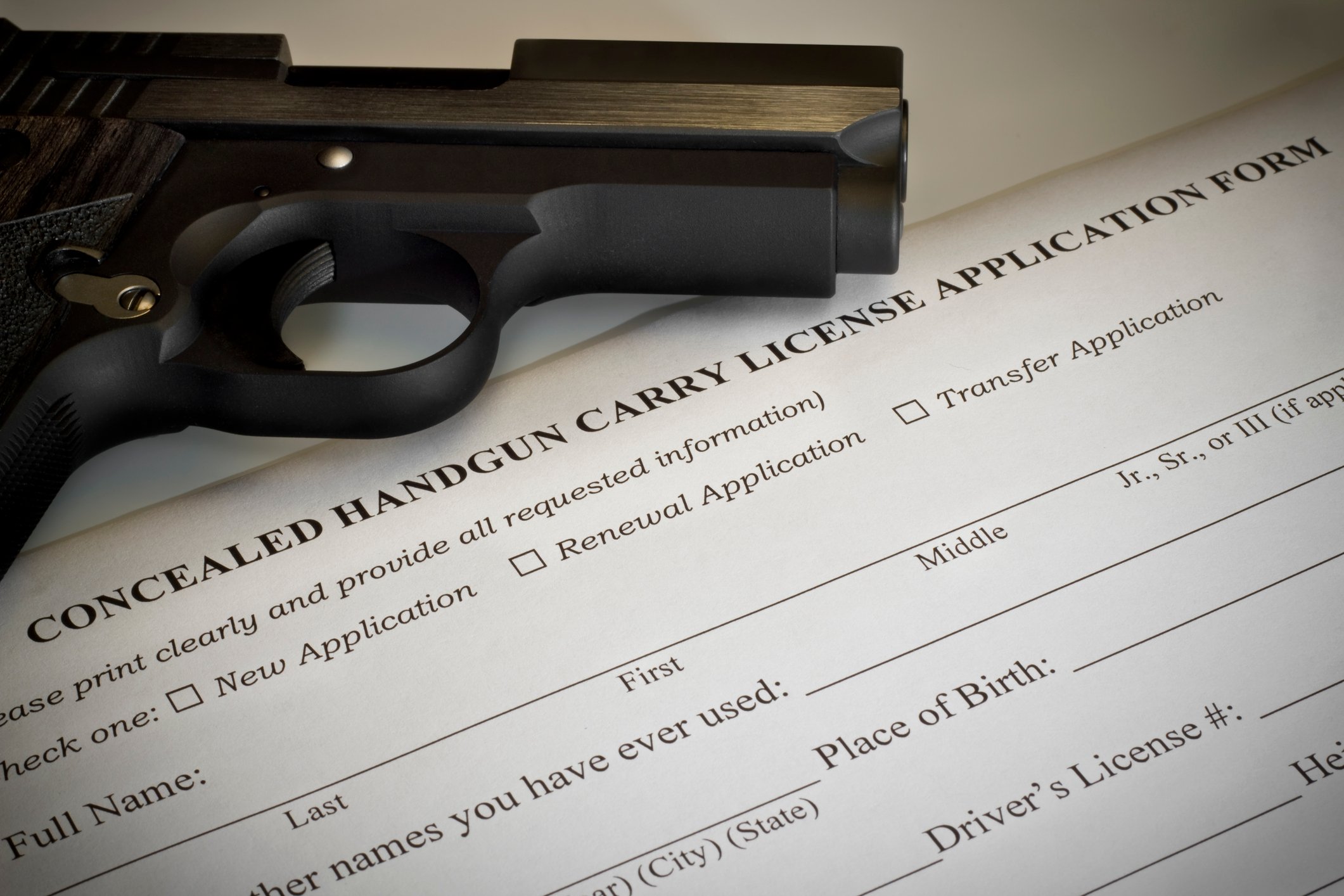 Pistol laying on a concealed carry permit application