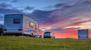 RV Sitting With a Car at Sunset