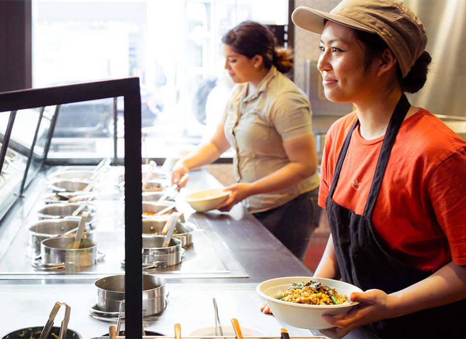 Employees at ShopHouse on the food assembly line.