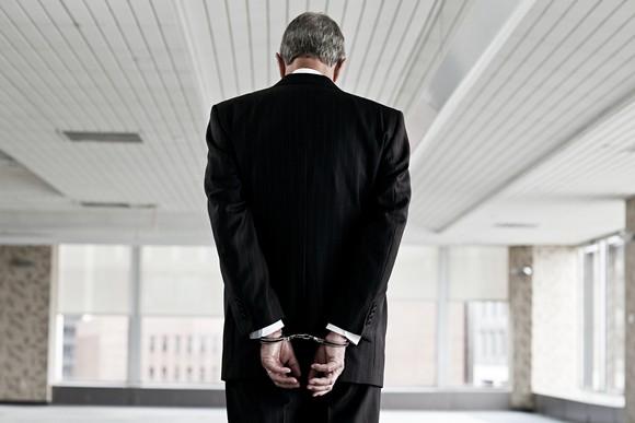 A businessman in handcuffs.
