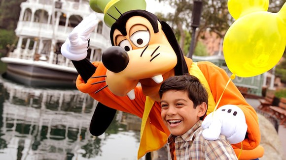 Boy with Disney character Goofy the dog at Disneyland. 