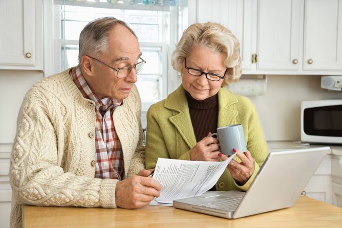 Older couple looking over financial paperwork.