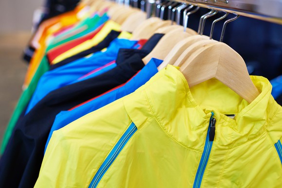 Sports coats hanging on a retail rack.