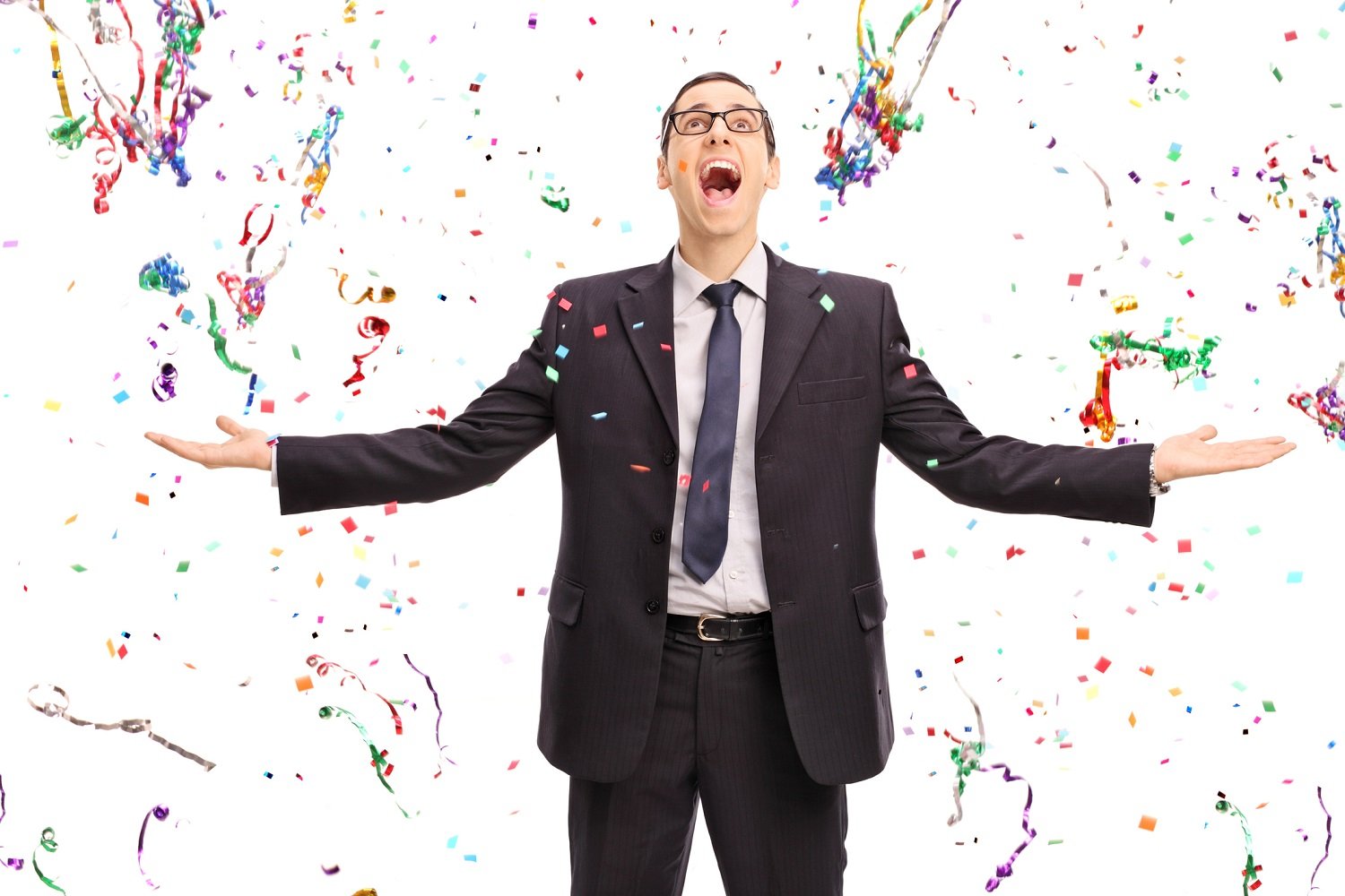 Business man with confetti falling around him, excited look on his face. 