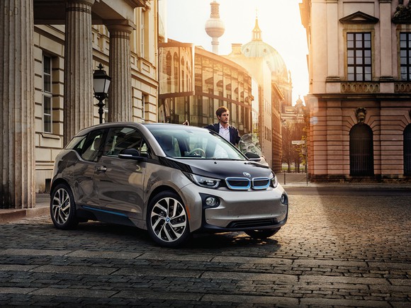BMW i3 parked on cobblestone road at dusk