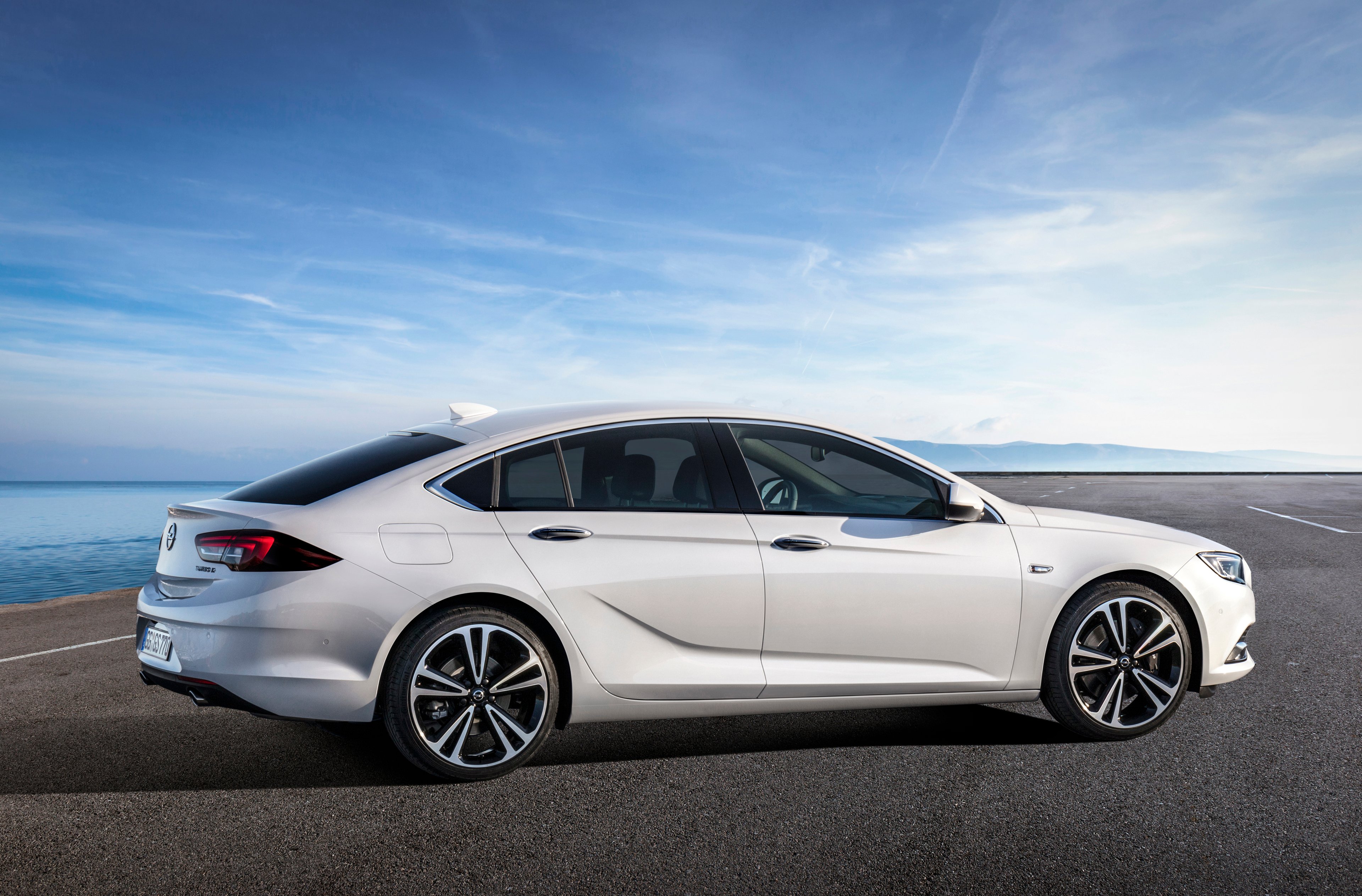 A white 2018 Opel Insignia Grand Sport in a parking lot on a sunny day. 