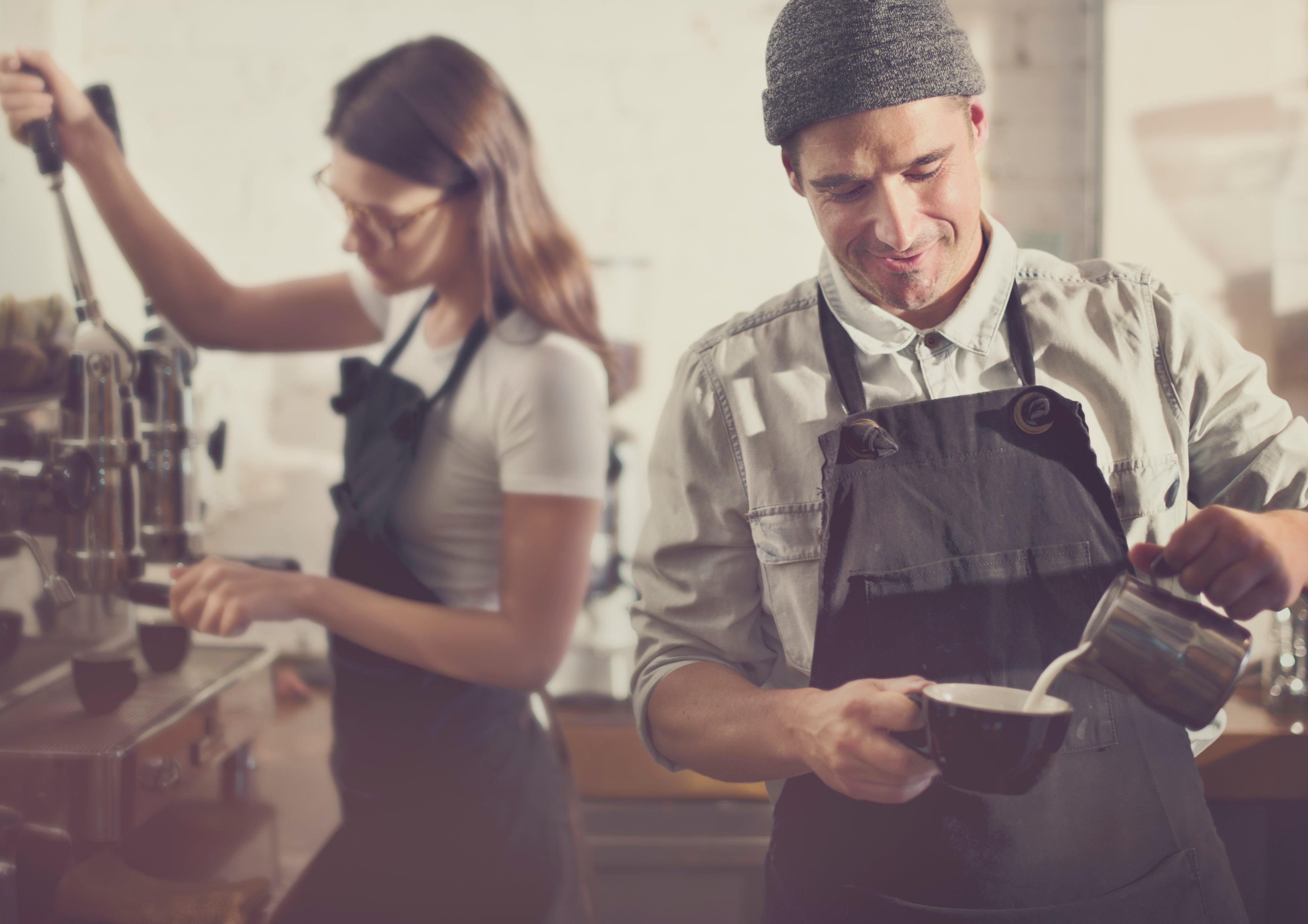 Two baristas prepare coffee.