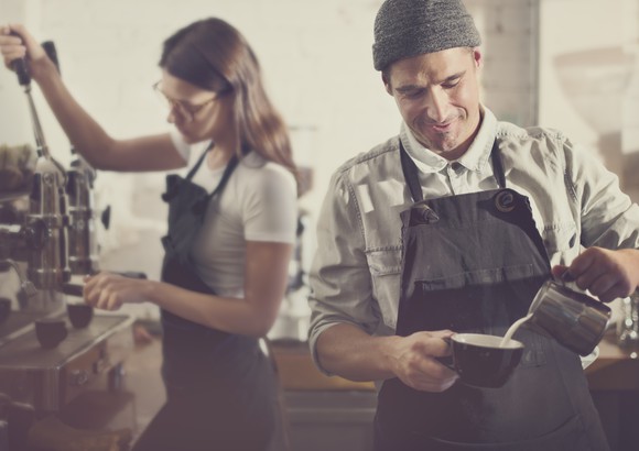 Two baristas prepare coffee.
