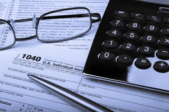 Tax form with glasses, pen, and calculator