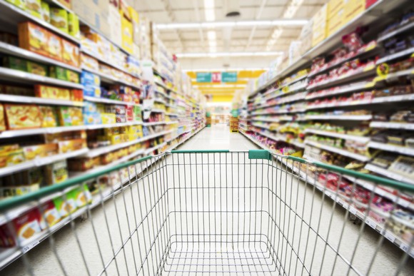 A shopping cart in a store aisle. 