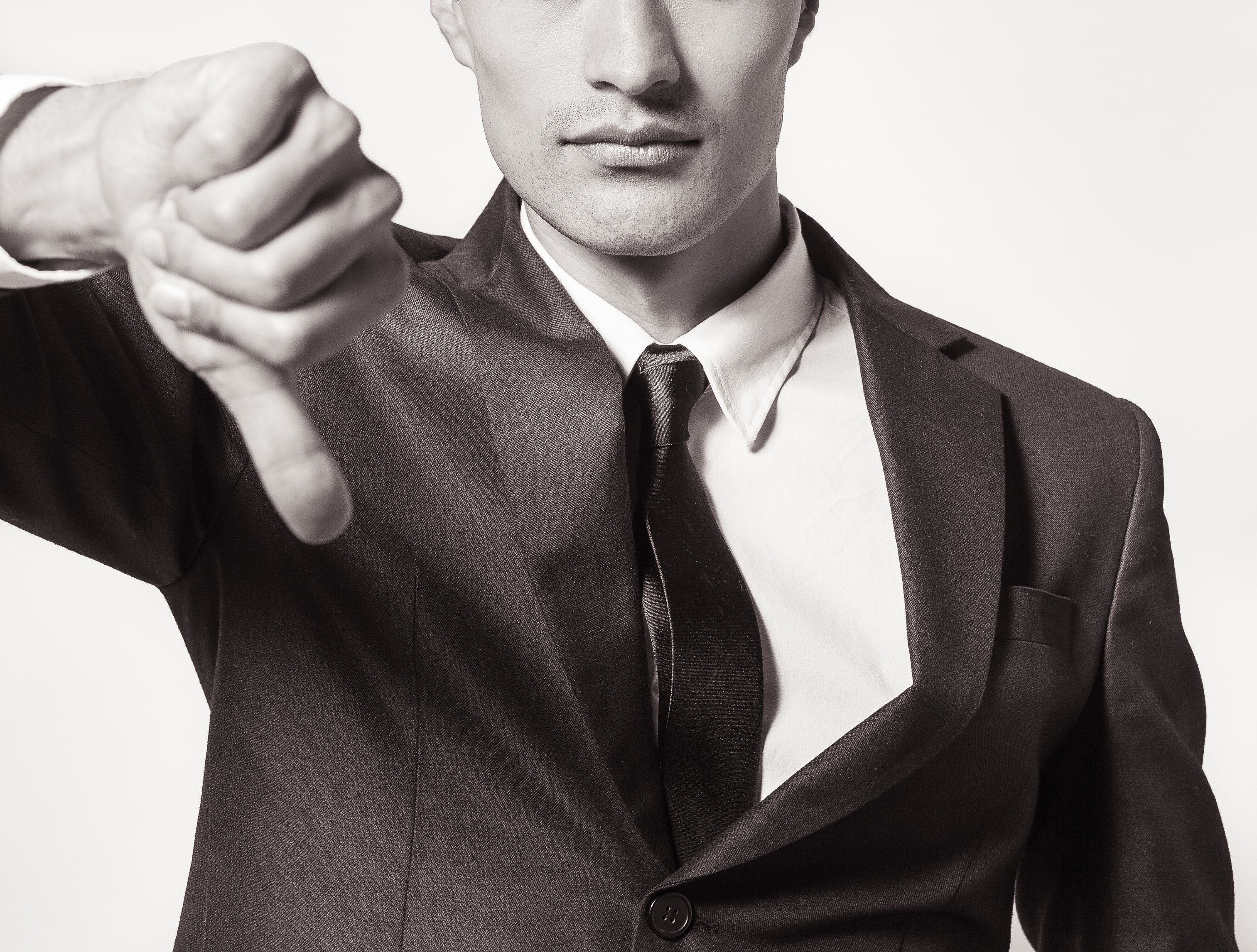 Man in suit giving thumbs down