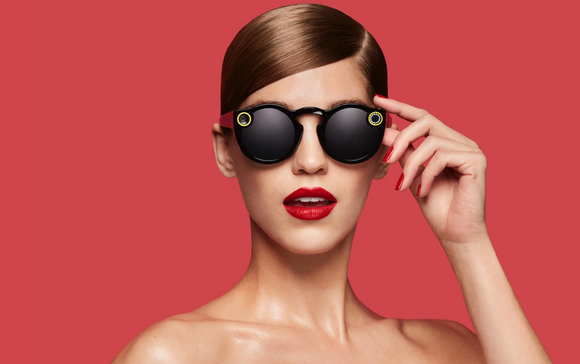 Model on red background wearing Snap Spectacles