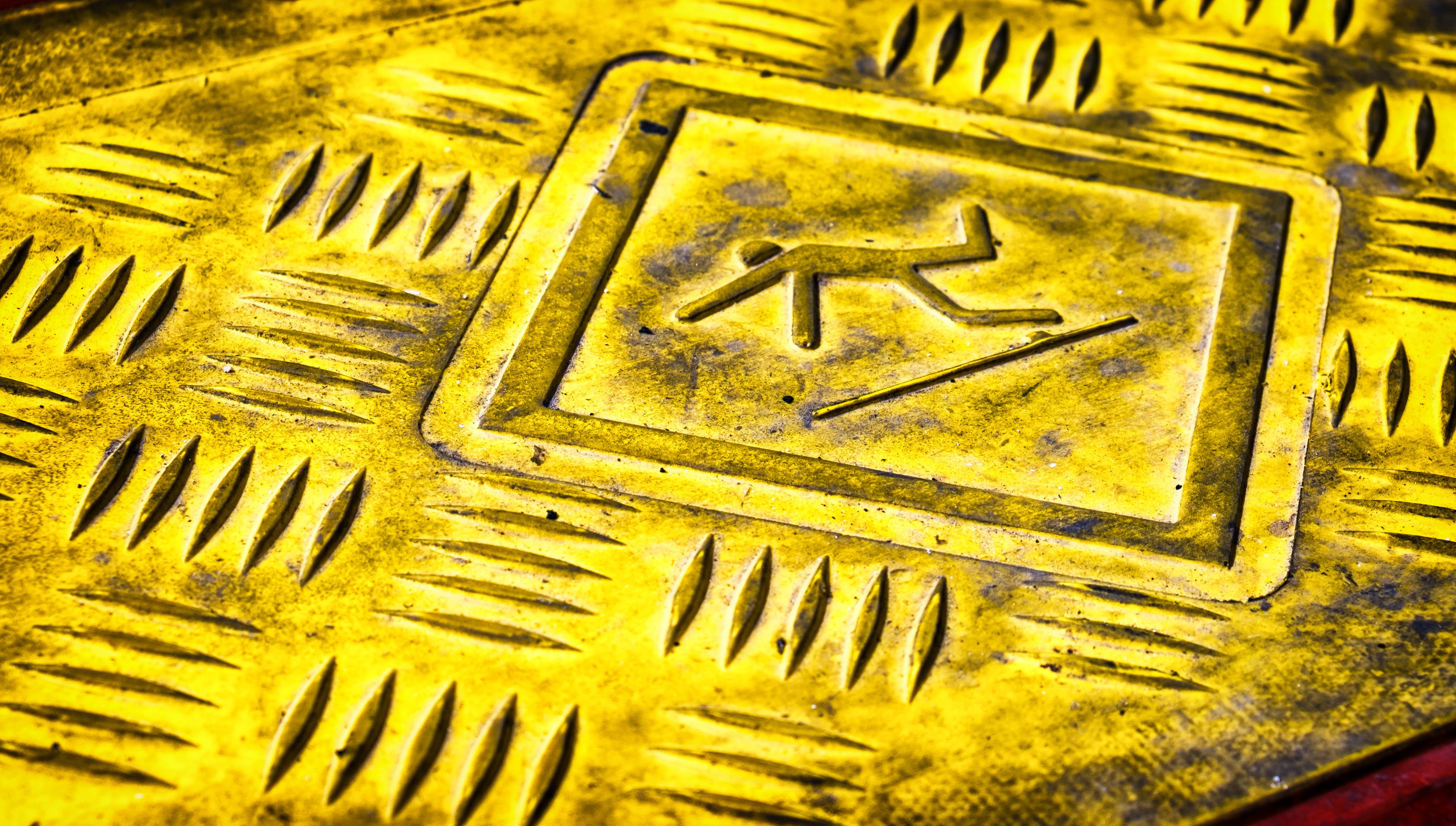 Caution sign with stick figure slipping.