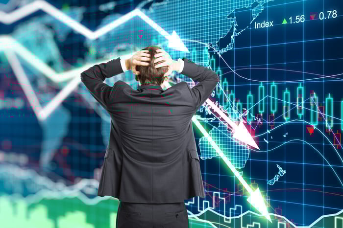 Businessman looking at declining stock charts