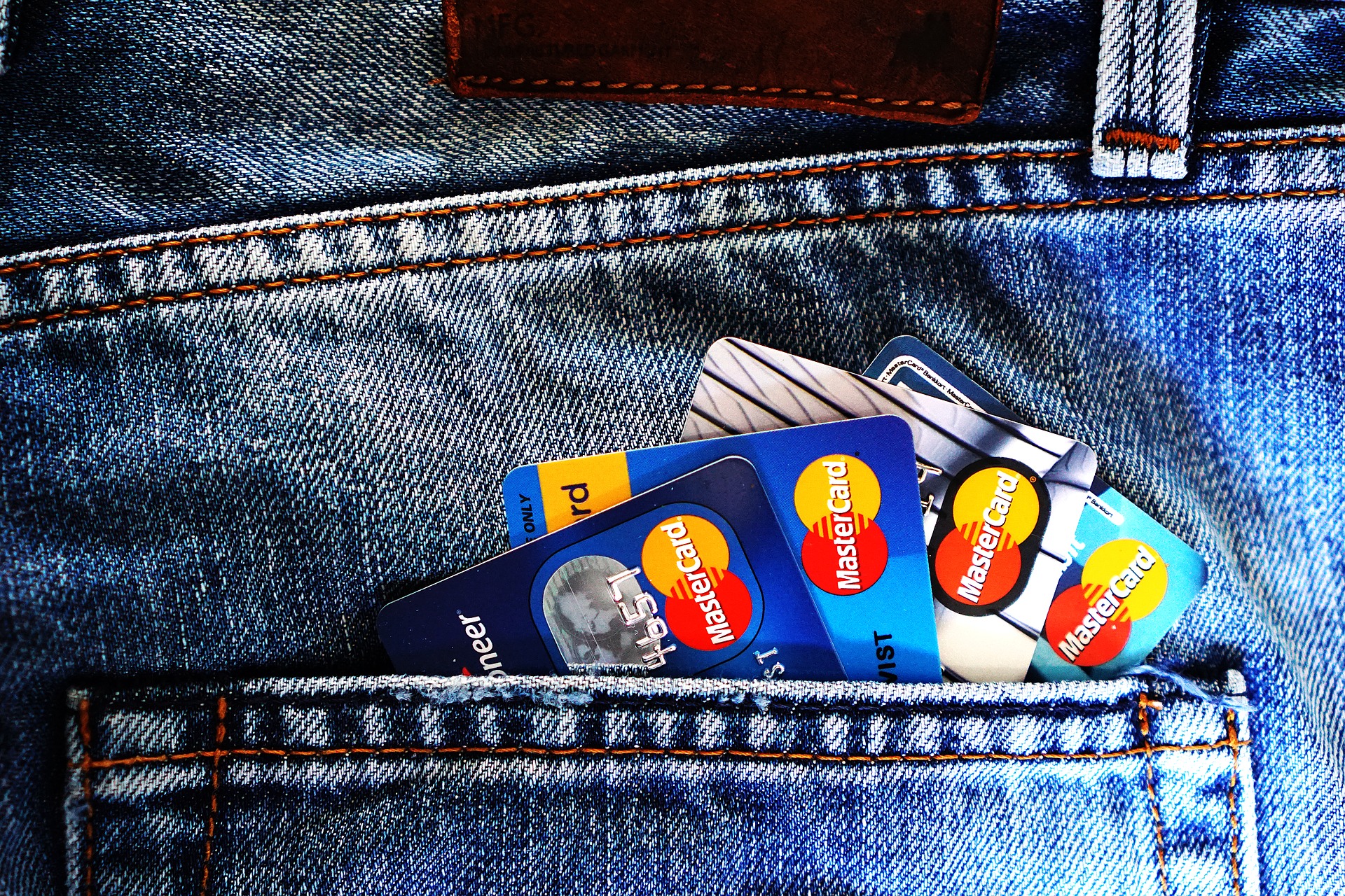 MasterCard brand credit cards sticking out of jeans pocket.