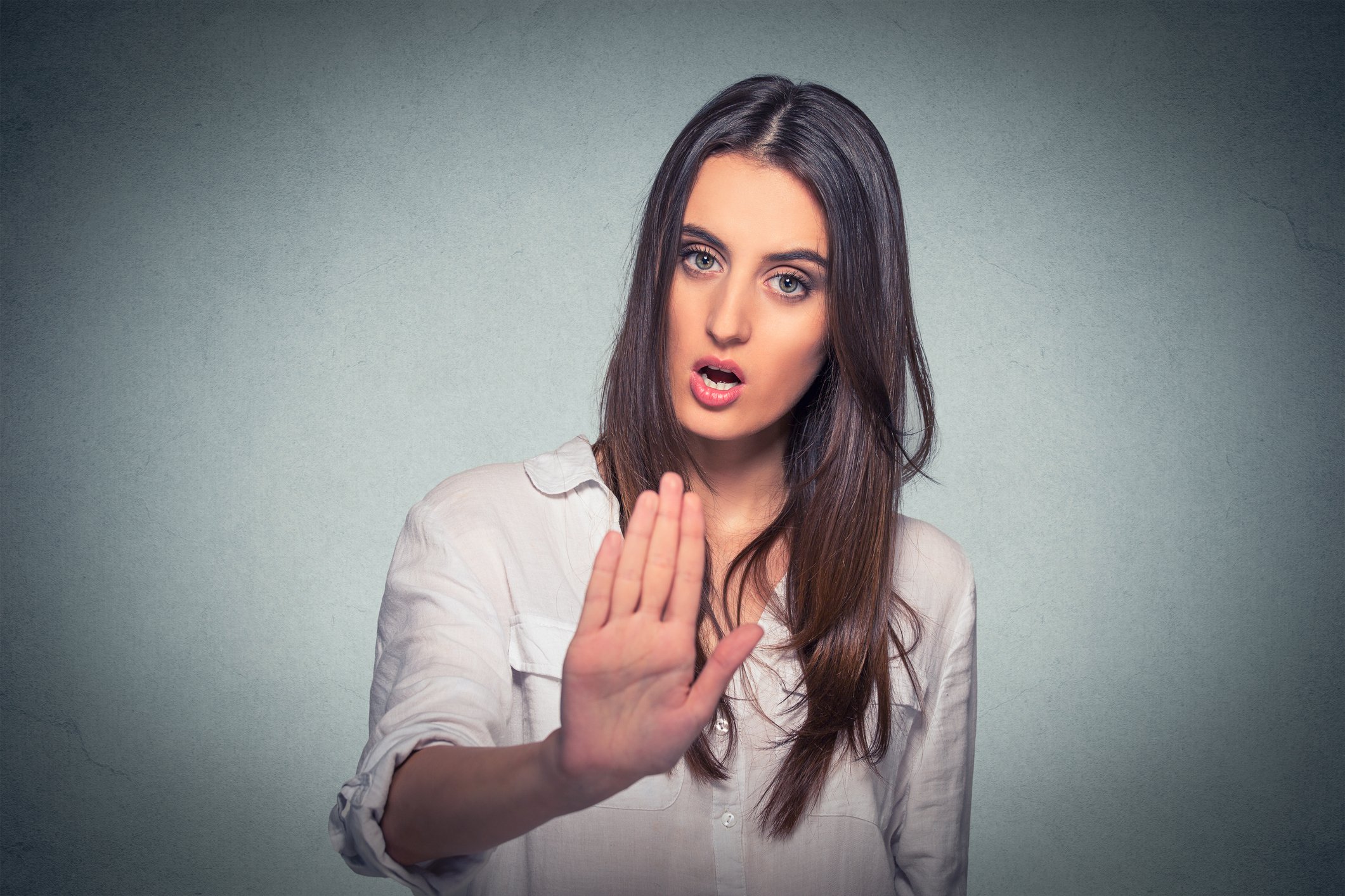Woman with hand held up, as if keeping someone away