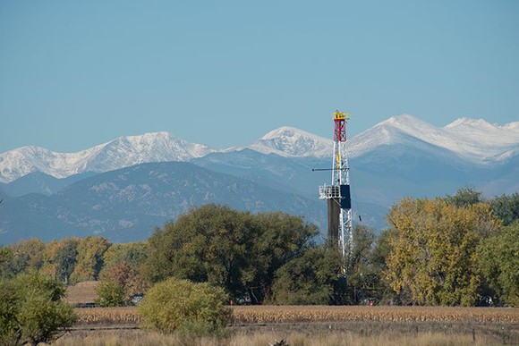 A drilling rig with mountains in the background. 