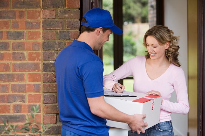 A woman signing for a package.