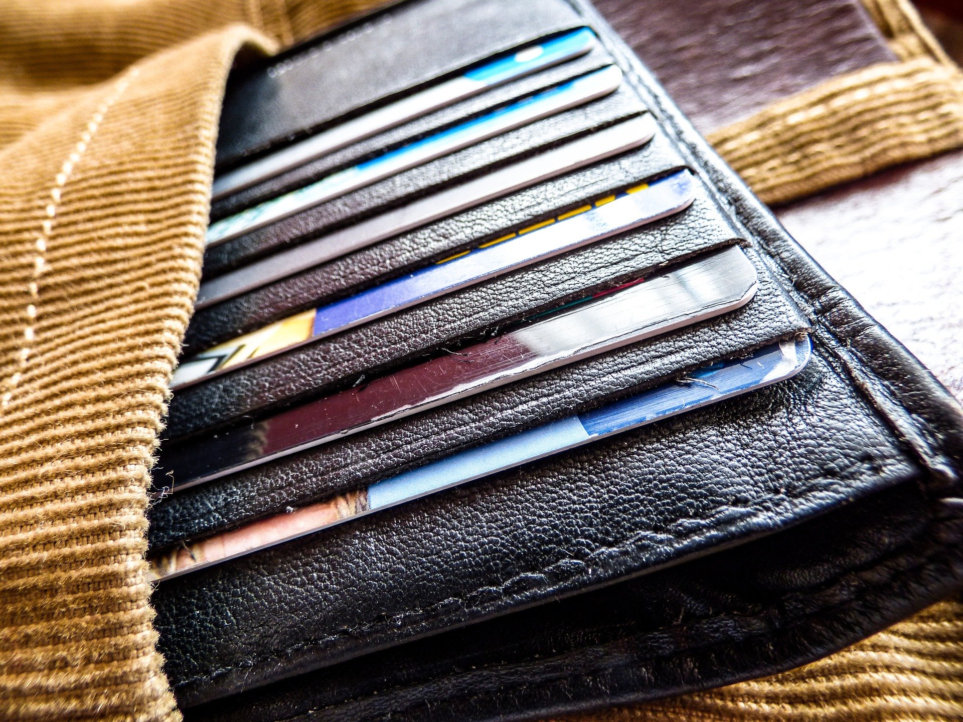 An open wallet, full of credit cards, sticking out of a pocket.