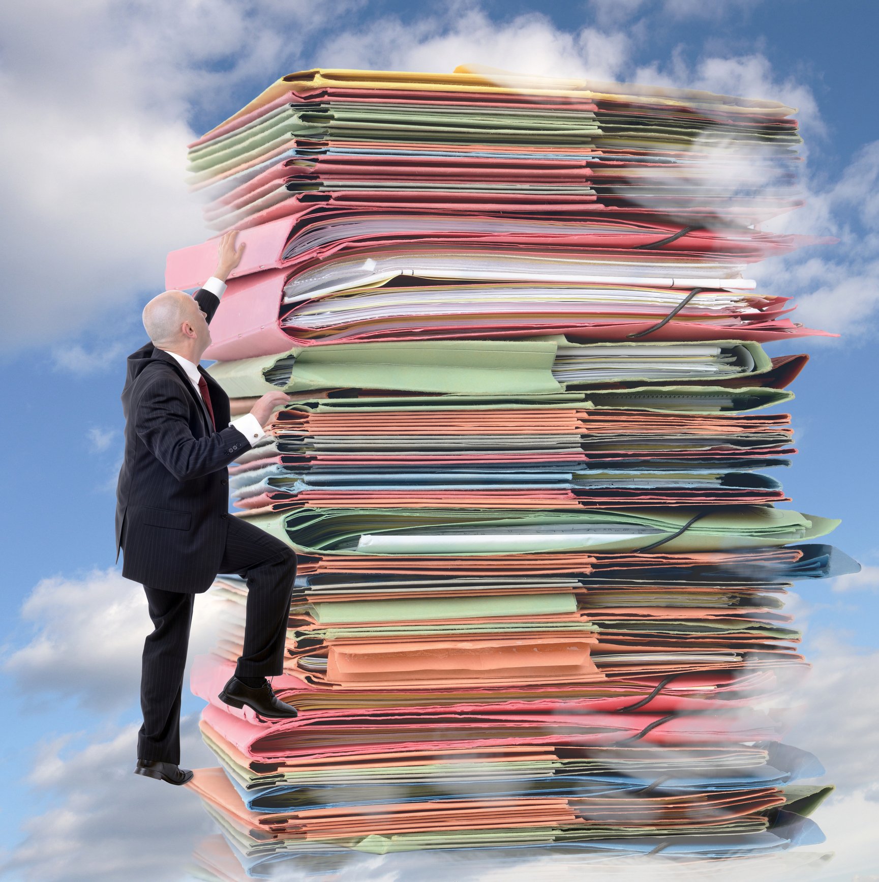 Man climbing a sky-high stack of paperwork