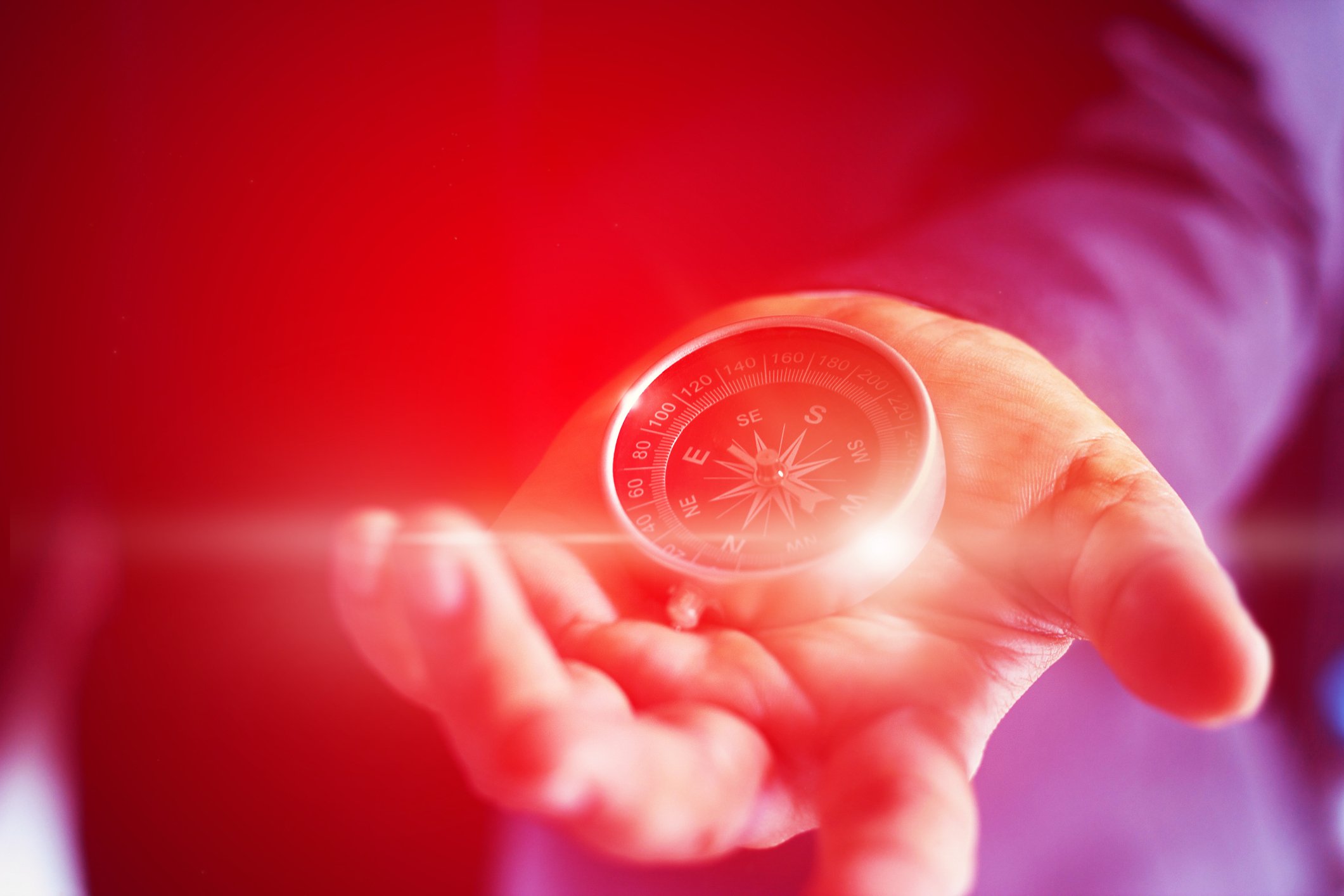 A man holding out a compass.