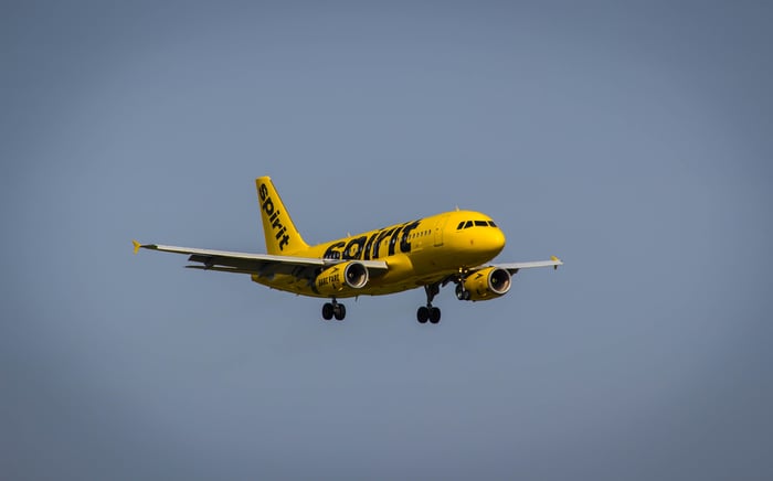 Yellow liveried plane cruising in sky.