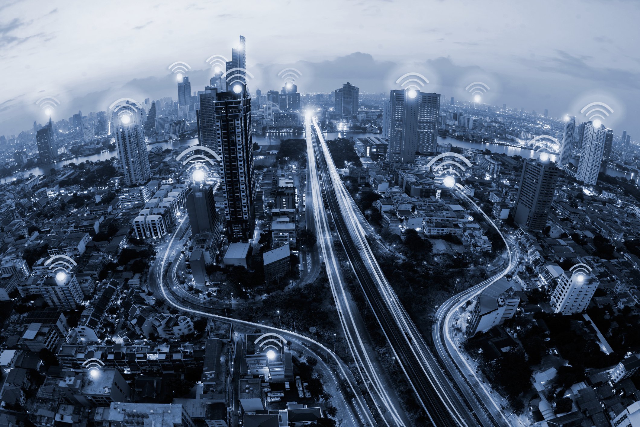 A city scape with animated lines of electricity running across it and the classic "wifi" symbol on many of the buildings.