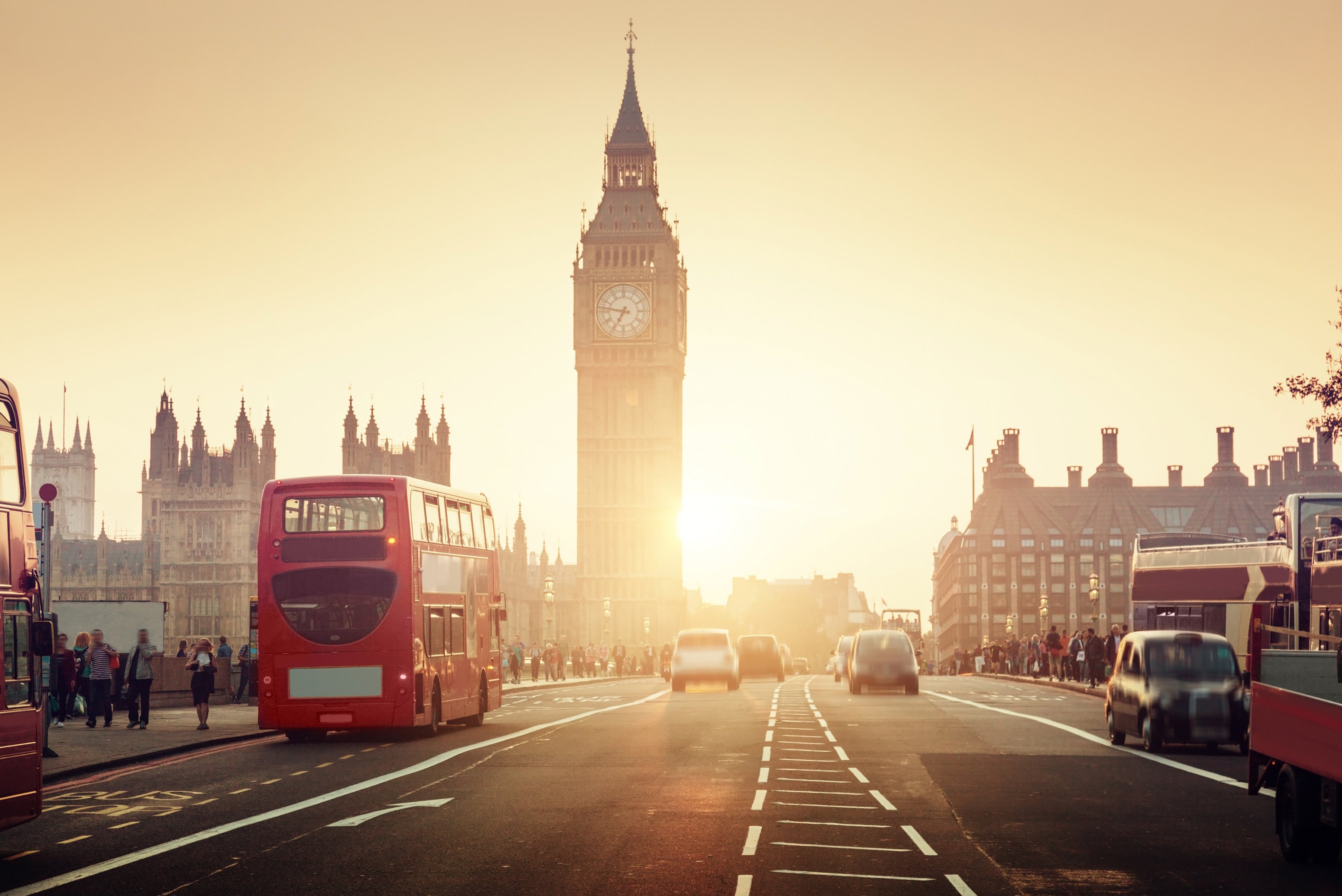 The famous Westminster Bridge with the sun setting over a double decker bus in London. 