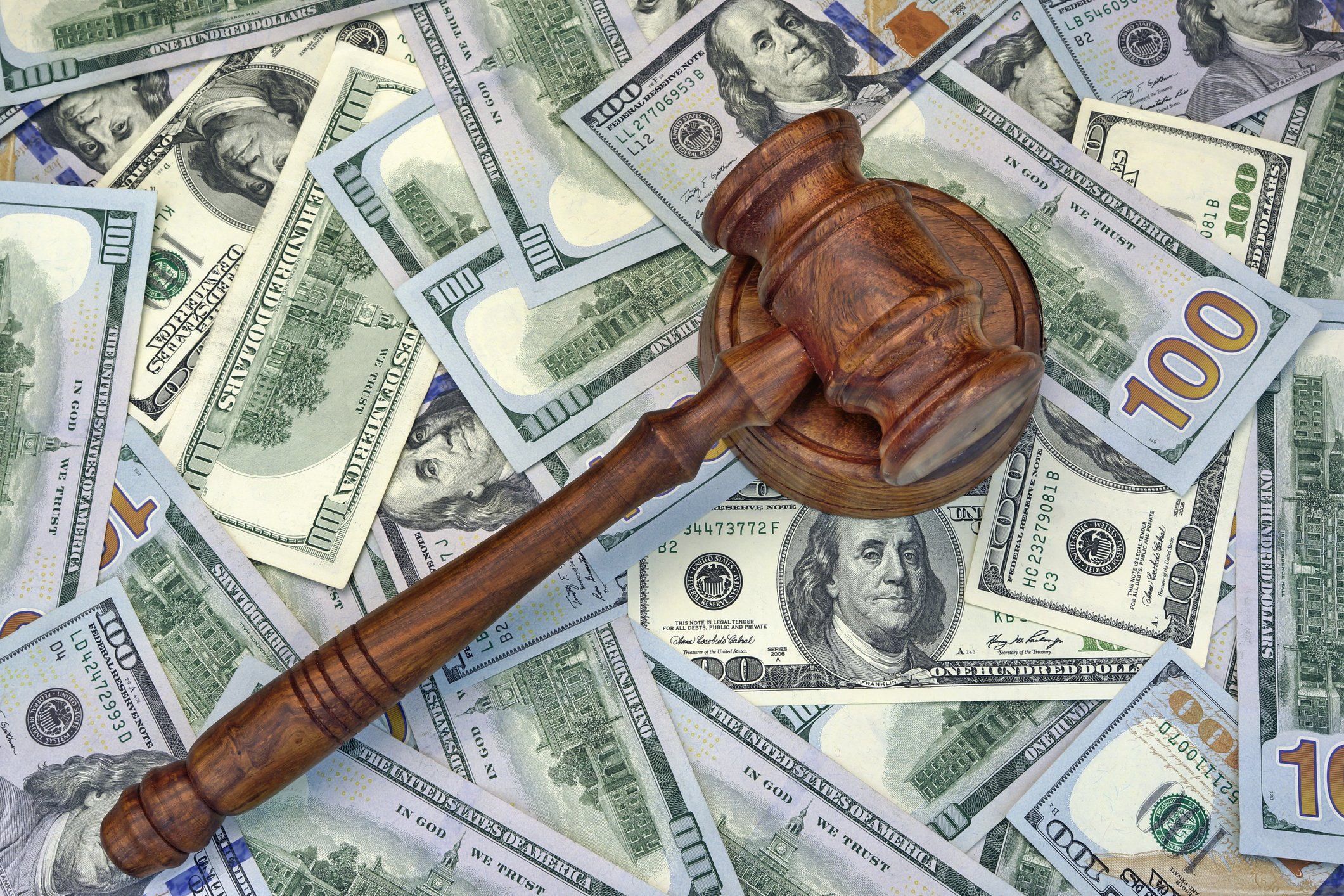A gavel sitting atop a pile of cash, representing the health law requiring the non-insured to pay the Shared Responsibility Payment.